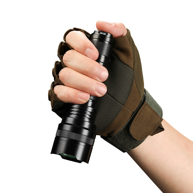 Hand holding a compact rechargeable high-power LED flashlight with textured grip and tactical glove