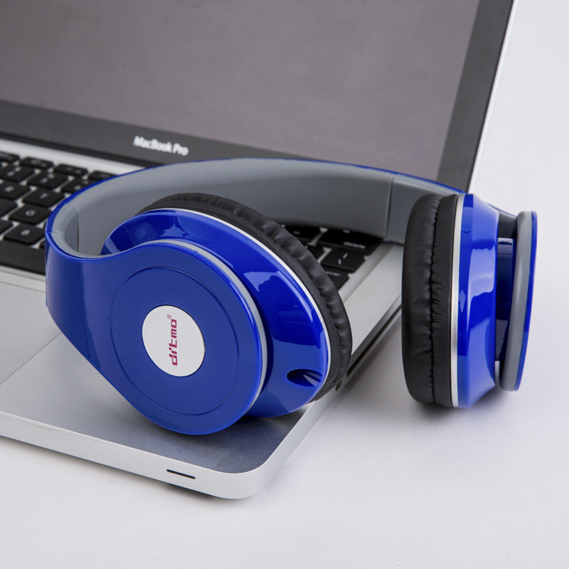 Blue wired over-ear gaming headphones with cushioned ear pads resting on silver laptop keyboard