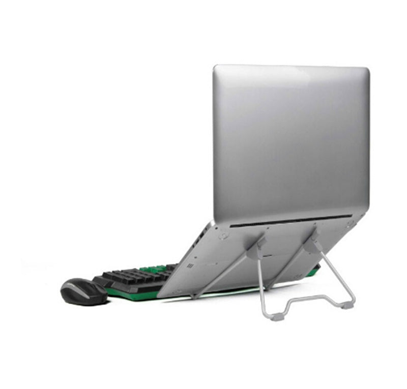 Silver adjustable laptop stand holding closed laptop beside wireless keyboard and mouse on white background